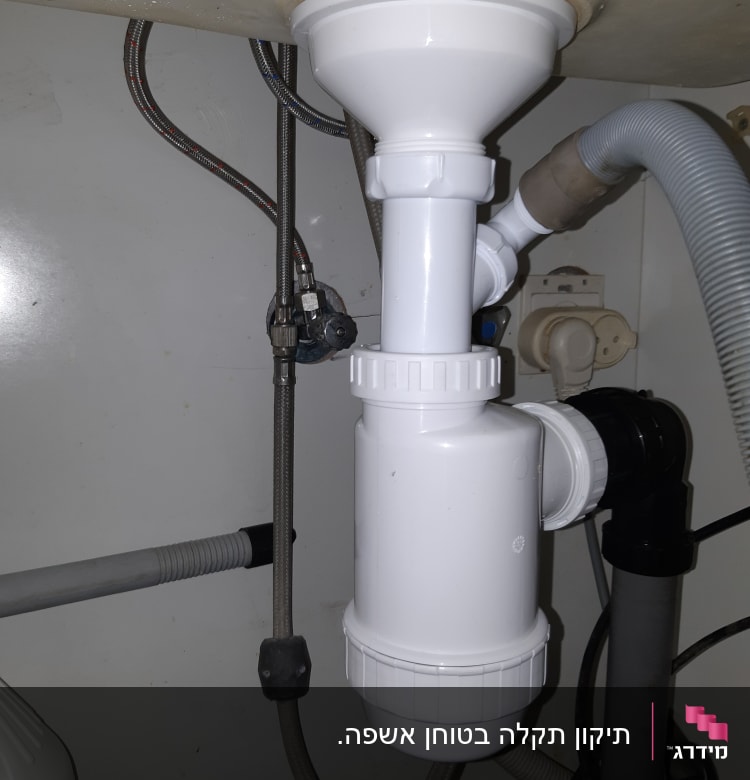 צנרת פלסטיק לבנה מתחת לכיור עם חיבורים